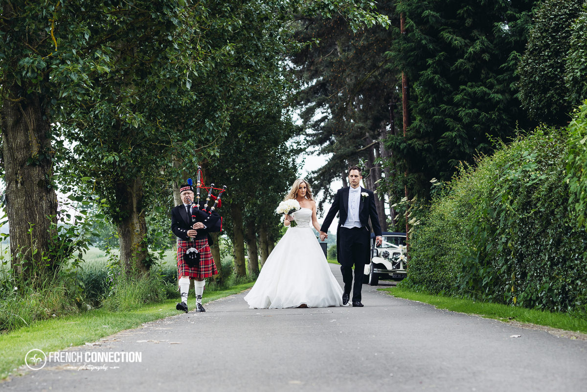 bride and groom walking along packington driveway